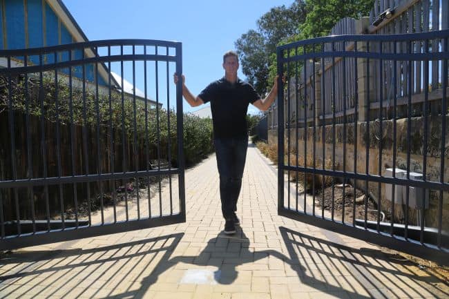 WA Gates owner, Ehud Powitzer, standing by newly installed electric gates in perth
