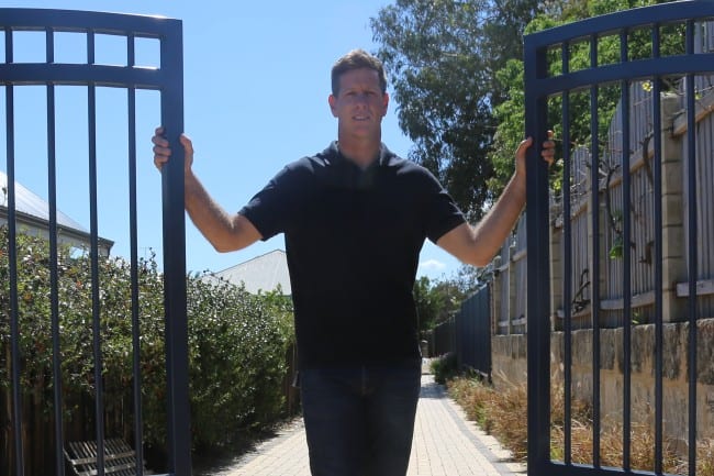 WA Gates owner, Ehud, standing next to an automatic gate.