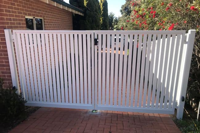 white automatic gate preventing access down side of the house.