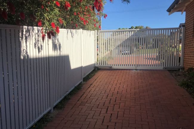 looking down the driveway and through the automatic gate to the street